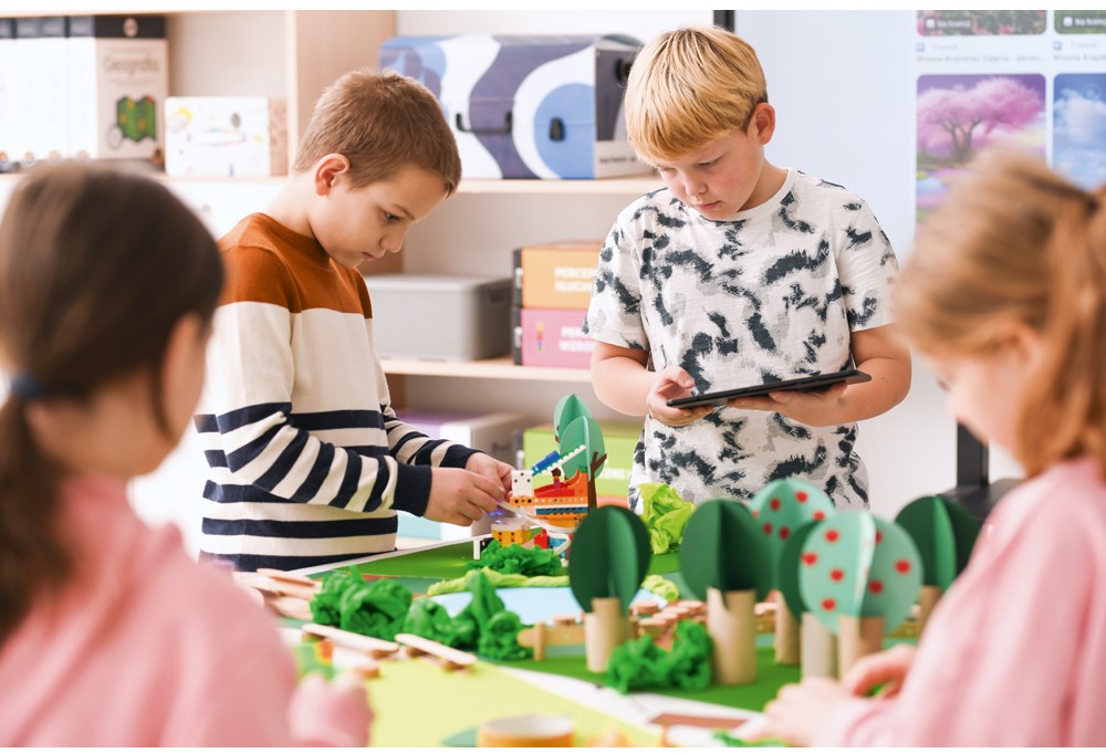 Žiaci spolupracujú na stavbe modelu z LEGO Education Science 11+ pri spoločnom stole v triede