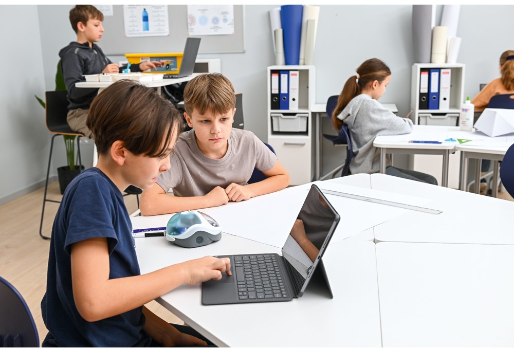 Žiaci pracujú s robotom Loti-Bot a tabletom počas spoločnej programovacej aktivity v triede.