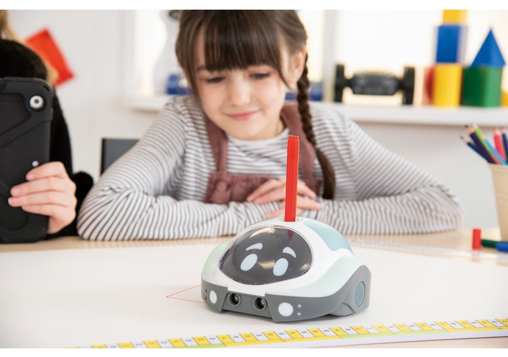 Žiačka pracuje s robotom Loti-Bot pri skúmaní uhlov a kreslení čiar na podložke.