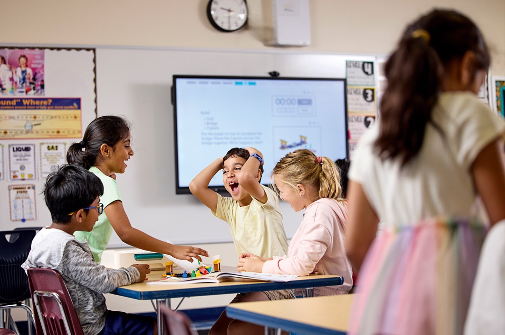 Skupina žáků nadšeně spolupracuje při aktivitě s LEGO Education. Učení hrou a radost z objevování.
