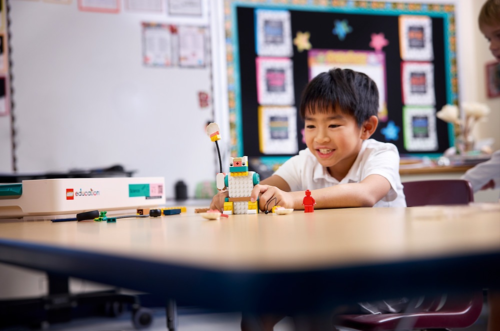 Chlapec ve třídě si hraje s postaveným modelem z LEGO Education. Rozvoj technického myšlení a jemné motoriky.